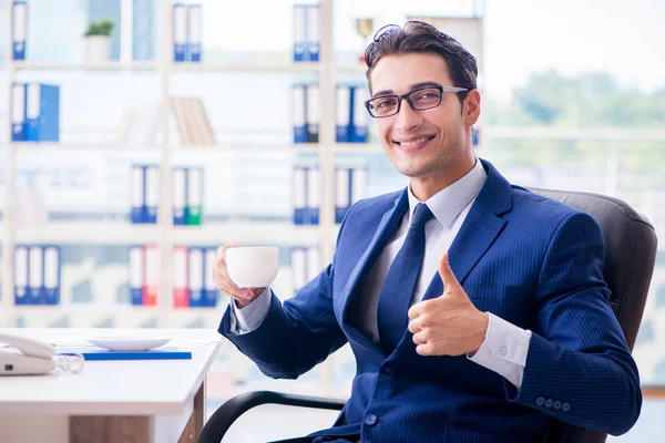 Businessman drinking coffee in the office during break — Stock Photo, Image