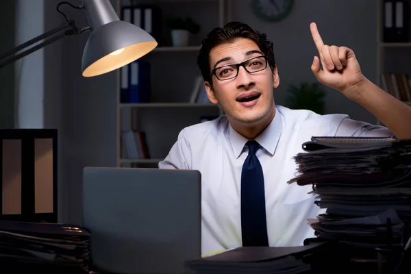 Joven hombre de negocios trabajando horas extras hasta tarde en el cargo — Foto de Stock