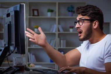 Genç adam fazla mesai yapmak için geç saatlere kadar ofiste kalıyor.