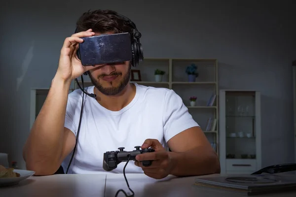 Jovem jogando jogos longas horas atrasado no escritório — Fotografia de Stock