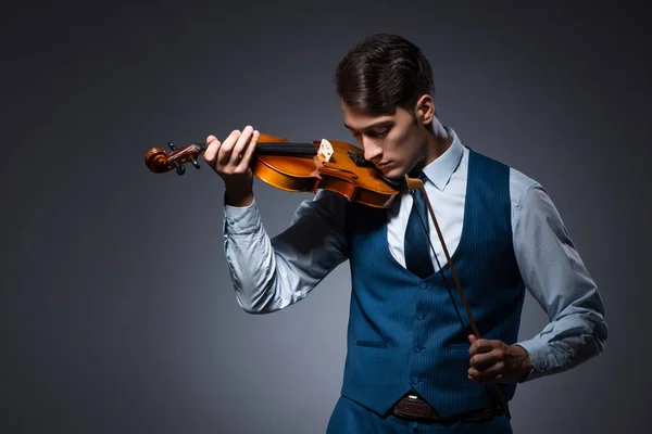 Jovem tocando violino no quarto escuro — Fotografia de Stock