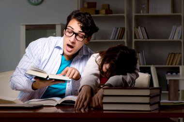 İki öğrenci geç saatlere kadar çalışıp sınavlara hazırlanıyor.