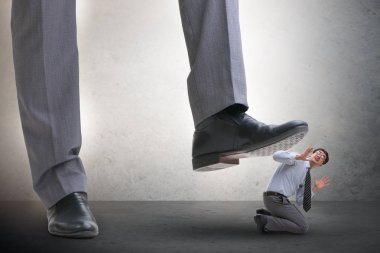 Kötü patron iş konseptinde çalışanın üzerine basıyor.