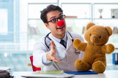 Hastane kliniğinde oyuncak taşıyan komik bir çocuk doktoru.