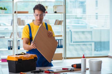 Mobilya marangozu atölyede çalışıyor.