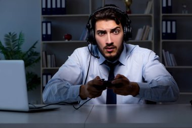 İş adamı oyuncu oyun oynamak için geç saatlere kadar kalıyor