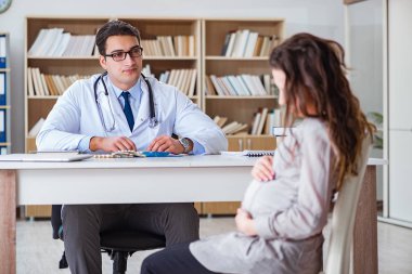 Hamile kadın muayene için doktoru ziyaret ediyor.
