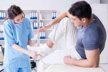 Hastanede yaralanma kontrolü sırasında doktor ve hasta.