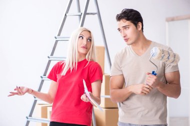 Ev tadilatı sırasında genç bir aile boya işi yapıyor.