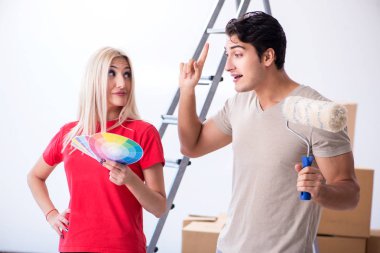 Ev tadilatı sırasında genç bir aile boya işi yapıyor.