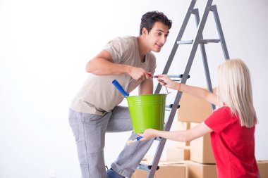 Ev tadilatı sırasında genç bir aile boya işi yapıyor.