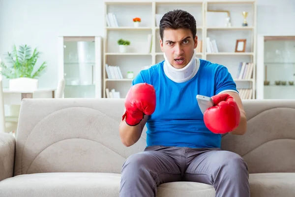Man med nackskador titta på boxning hemma — Stockfoto