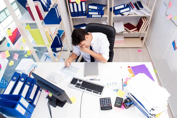 Businessman working in the office with piles of books and papers — Stock Photo, Image