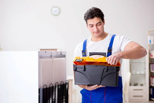 Reparador contratante reparação de geladeira no conceito DIY — Fotografia de Stock