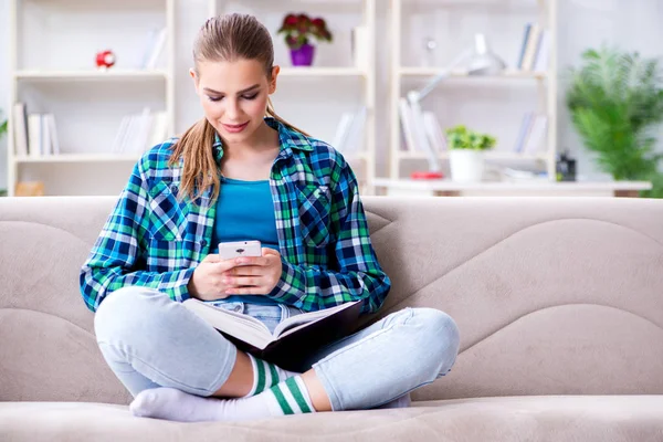 Studentin liest Buch sitzend auf dem Sofa — Stockfoto