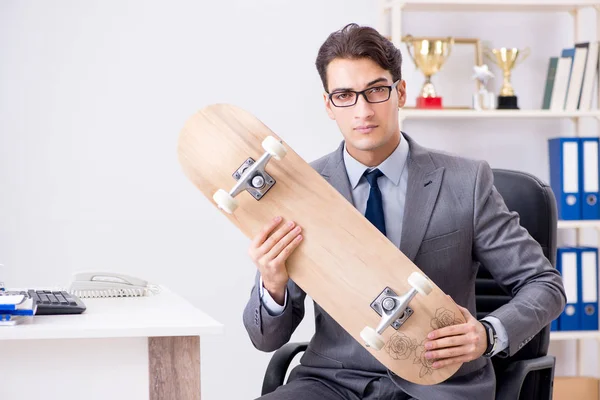 Young businessman riding skate in office during break — Stock Photo, Image