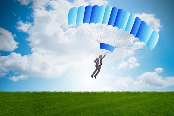 Молодий бізнесмен падає на парашут в бізнес-концепції — стокове фото