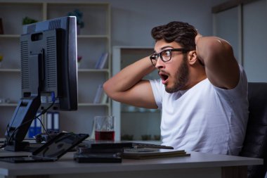 Genç adam fazla mesai yapmak için geç saatlere kadar ofiste kalıyor.