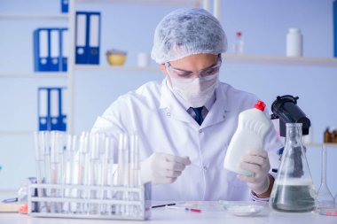 Laboratuvardaki adam yeni temizlik çözeltisi deterjanı test ediyor.