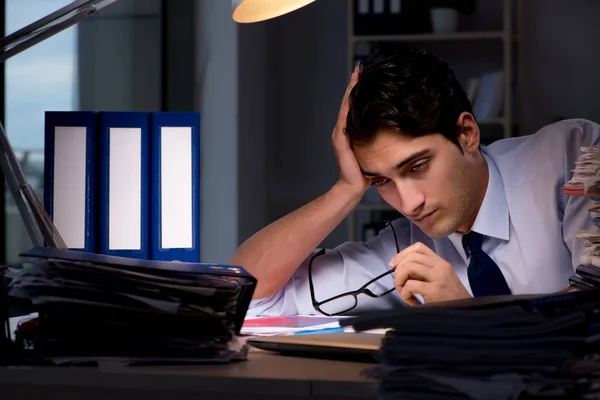 Joven hombre de negocios trabajando horas extras hasta tarde en el cargo —  Fotos de Stock