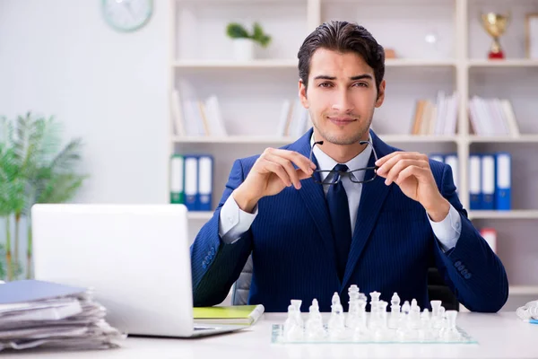 Joven hombre de negocios jugando ajedrez de vidrio en la oficina — Foto de Stock