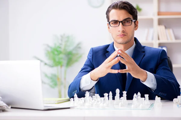 Junger Geschäftsmann spielt Glasschach im Büro — Stockfoto