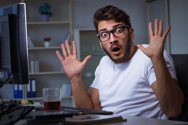 Joven que se queda hasta tarde en la oficina para hacer horas extras — Foto de Stock