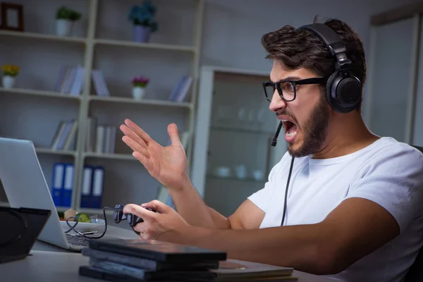 Jovem jogando jogos longas horas atrasado no escritório — Fotografia de Stock