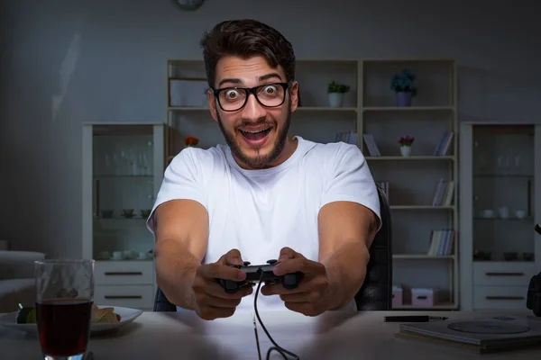 Jovem jogando jogos longas horas atrasado no escritório — Fotografia de Stock