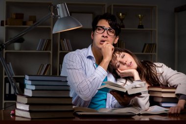 İki öğrenci geç saatlere kadar çalışıp sınavlara hazırlanıyor.