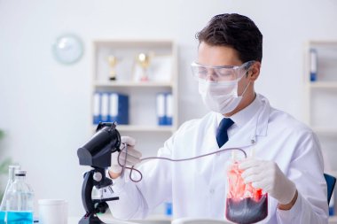 Hastane kliniğinde kan örnekleriyle çalışan bir doktor.