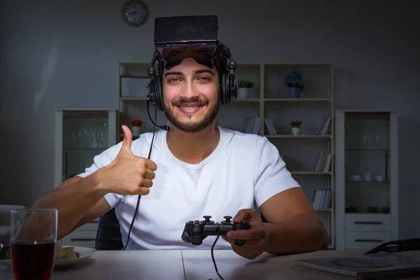 Jovem jogando jogos longas horas atrasado no escritório — Fotografia de Stock