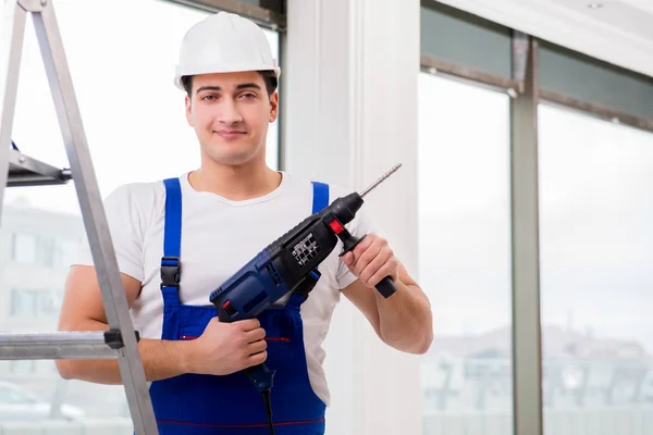 Reparador trabalhando com broca de energia na oficina — Fotografia de Stock