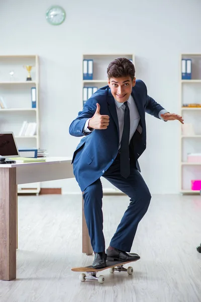 Young businessman with skate in office in sports concept — Stock Photo, Image