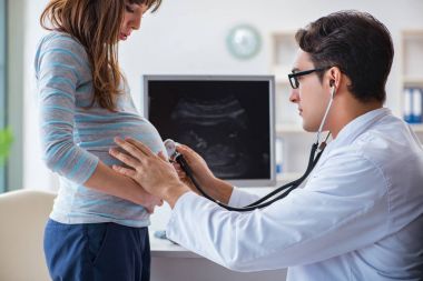 Hamile kadın düzenli kontrol için doktoru ziyaret ediyor.