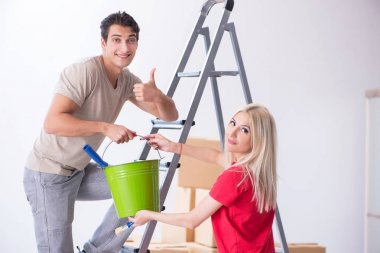 Ev tadilatı sırasında genç bir aile boya işi yapıyor.