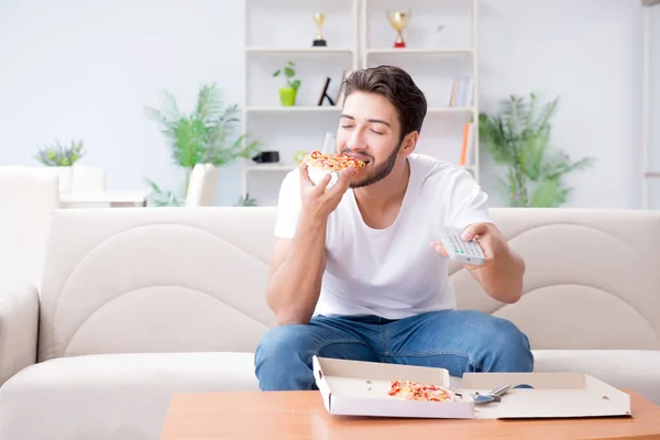 Hombre comiendo pizza teniendo una comida para llevar en casa descansando relajado — Foto de Stock