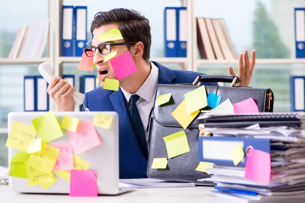 Affärsman med påminnelse anteckningar i multitasking koncept — Stockfoto