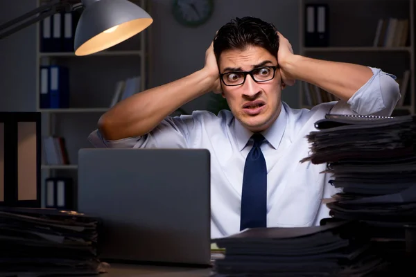 Young businessman working overtime late in office