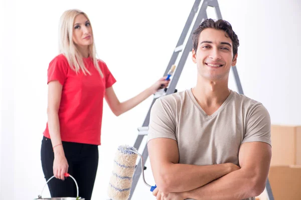 Giovane famiglia che fa lavoro di pittura durante la ristrutturazione della casa — Foto Stock