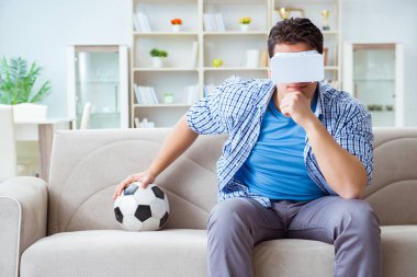 Sanal gerçeklik gözlüğü takan bir adam futbol maçı izliyor.