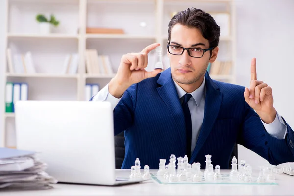 Joven hombre de negocios jugando ajedrez de vidrio en la oficina — Foto de Stock