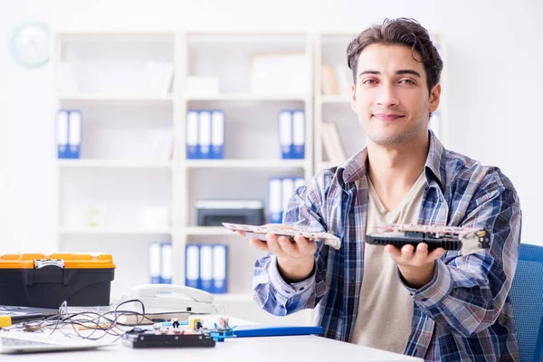 Professional repairman repairing computer in workshop