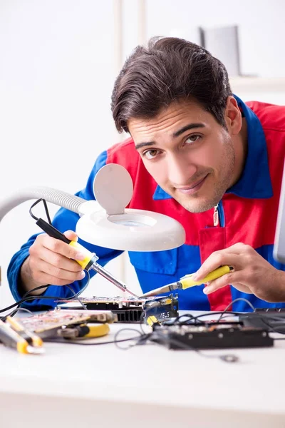 Professional repairman repairing computer in workshop