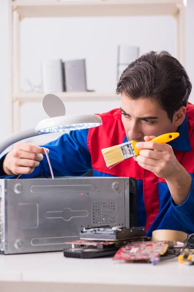 Professional repairman repairing computer in workshop