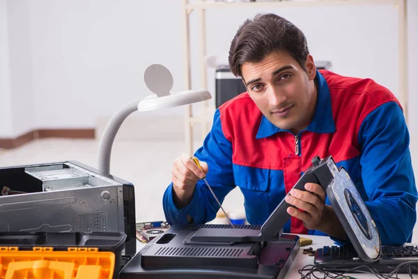 Professional repairman repairing computer in workshop