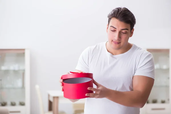 Junger Mann mit Geschenktüte bereitet Überraschung für Ehefrau vor — Stockfoto