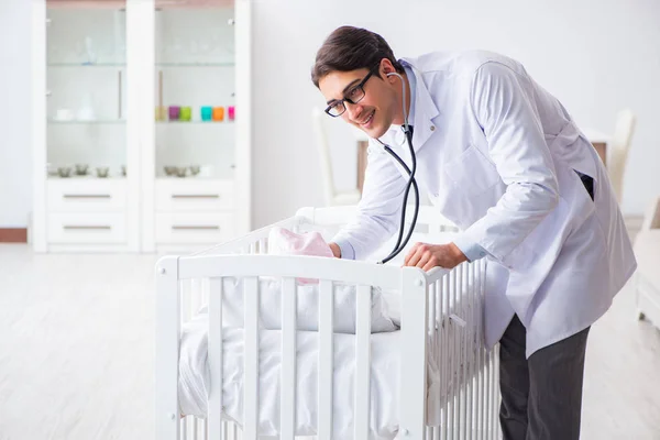 Erkek çocuk doktoru bebek yatağının yanında muayene etmeye hazırlanıyor. — Stok fotoğraf