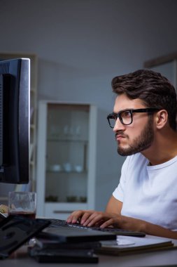 Genç adam fazla mesai yapmak için geç saatlere kadar ofiste kalıyor.