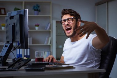 Genç adam fazla mesai yapmak için geç saatlere kadar ofiste kalıyor.